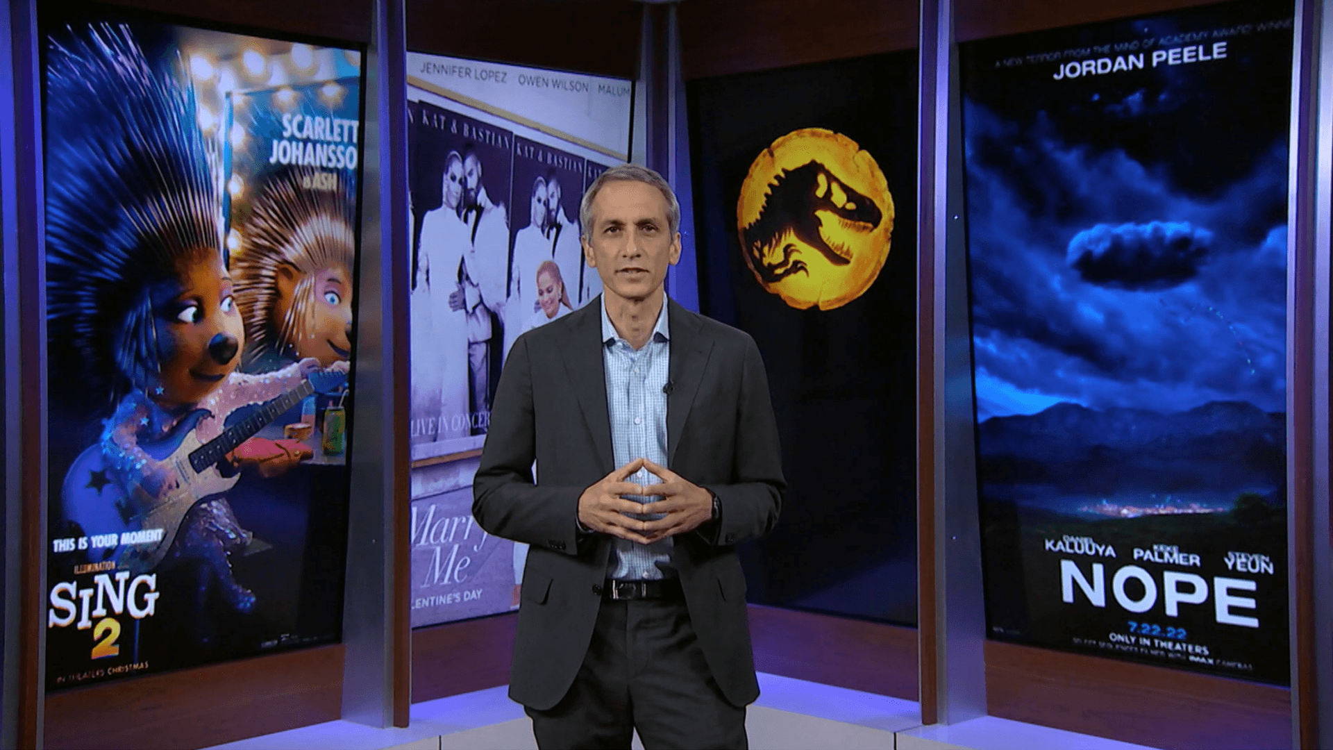 Universal Pictures President Peter Cramer stands in front of Universal film posters: Sing 2, Marry Me, Jurassic World: Dominion and Nope.